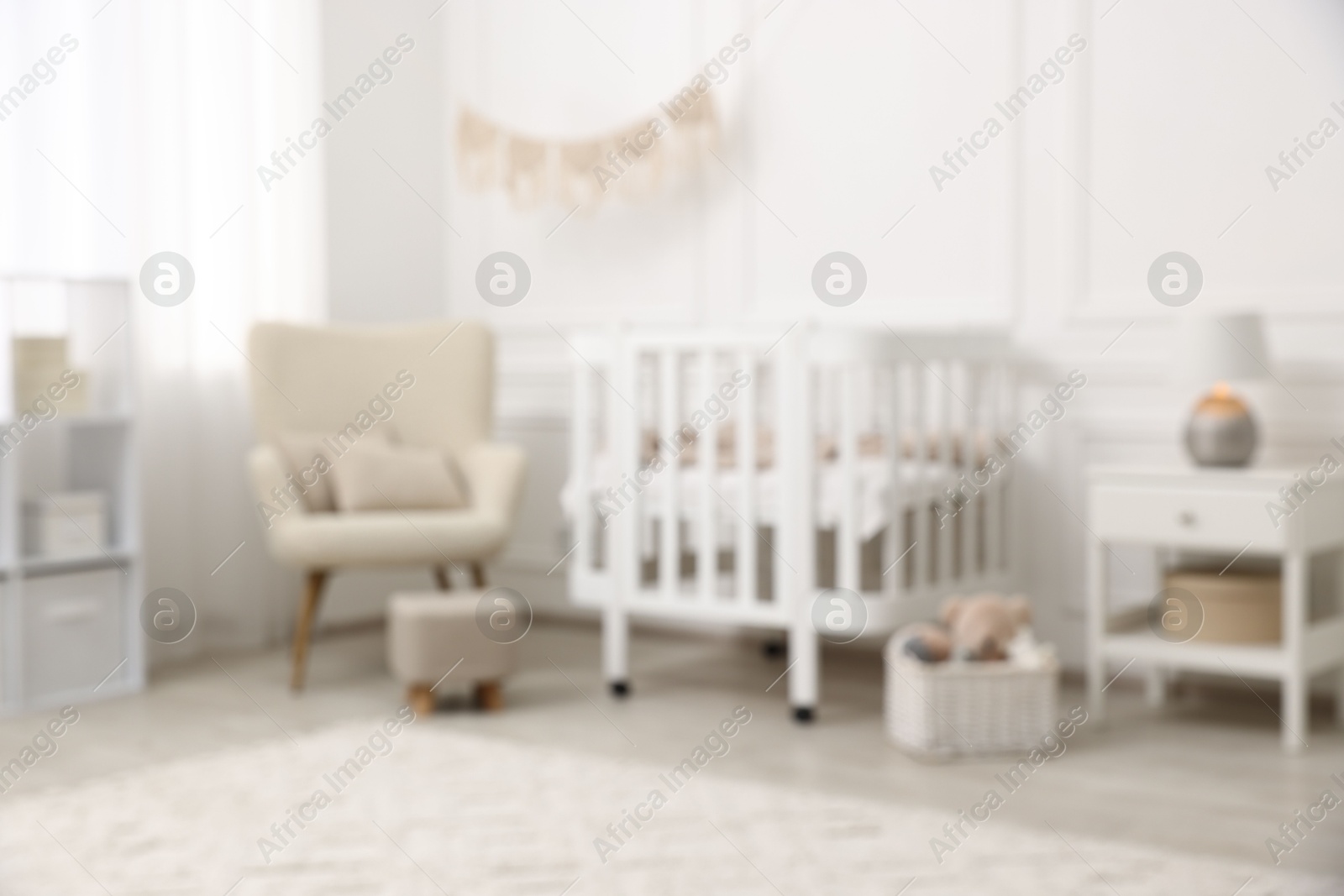 Baby room interior with crib and other furniture, blurred view Photo of Baby room interior with crib and other furniture, blurred view