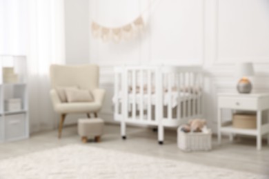 Photo of Baby room interior with crib and other furniture, blurred view