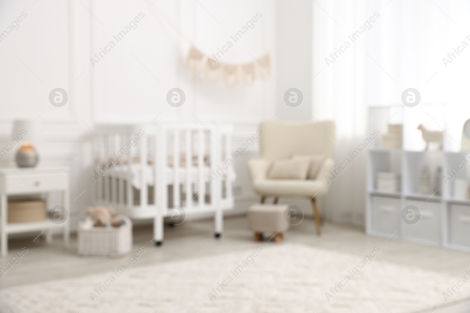 Baby room interior with crib and other furniture, blurred view Photo of Baby room interior with crib and other furniture, blurred view