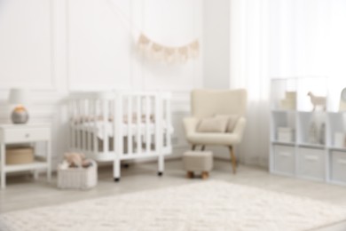 Photo of Baby room interior with crib and other furniture, blurred view