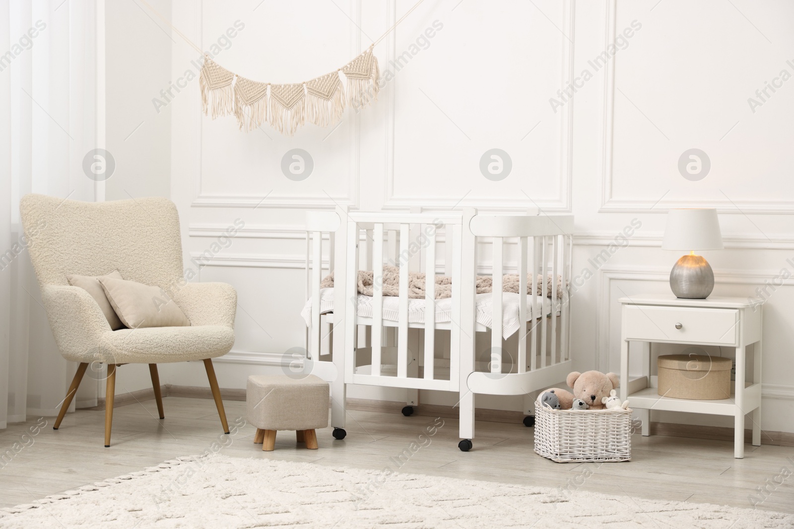 Stylish baby room interior with comfortable crib, armchair and toys Photo of Stylish baby room interior with comfortable crib, armchair and toys