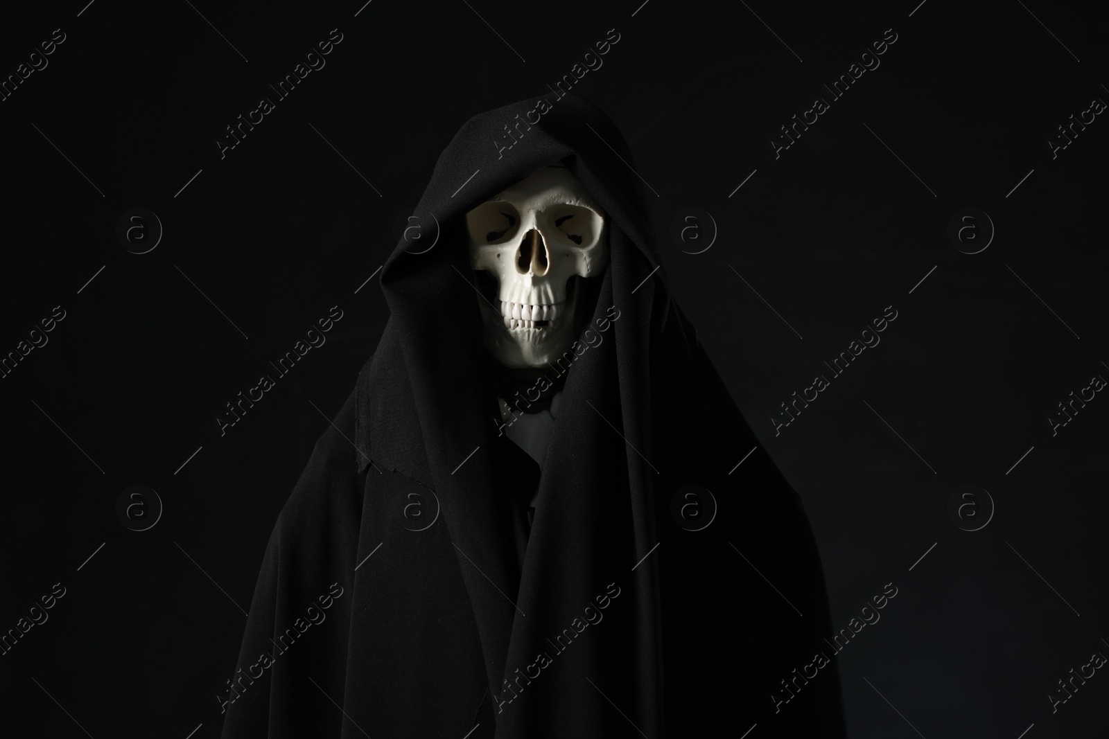 Creepy ghost. Skeleton covered with sheet on black background Photo of Creepy ghost. Skeleton covered with sheet on black background