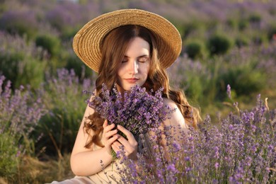 Photo of Beautiful young woman with lavender flowers in field