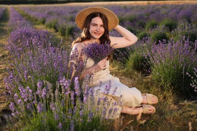 Photo of Beautiful young woman with lavender flowers in field