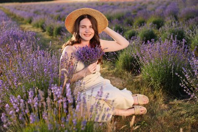 Photo of Beautiful young woman with lavender flowers in field