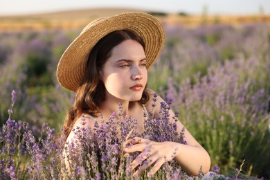 Photo of Beautiful young woman among lavender flowers in field