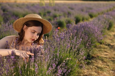 Photo of Beautiful young woman among lavender flowers in field. Space for text