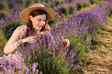 Photo of Beautiful young woman among lavender flowers in field