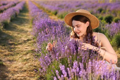 Photo of Beautiful young woman among lavender flowers in field