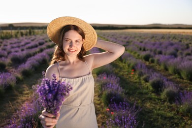 Photo of Beautiful young woman with lavender flowers in field