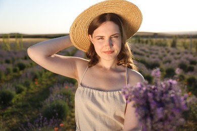 Photo of Beautiful young woman with lavender flowers in field