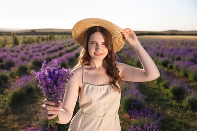 Photo of Beautiful young woman with lavender flowers in field