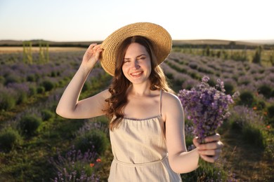 Photo of Beautiful young woman with lavender flowers in field