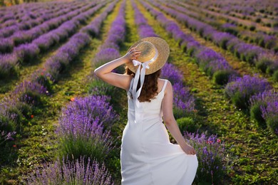 Photo of Woman with straw hat in lavender field, back view