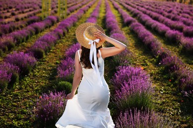 Photo of Woman with straw hat in lavender field, back view
