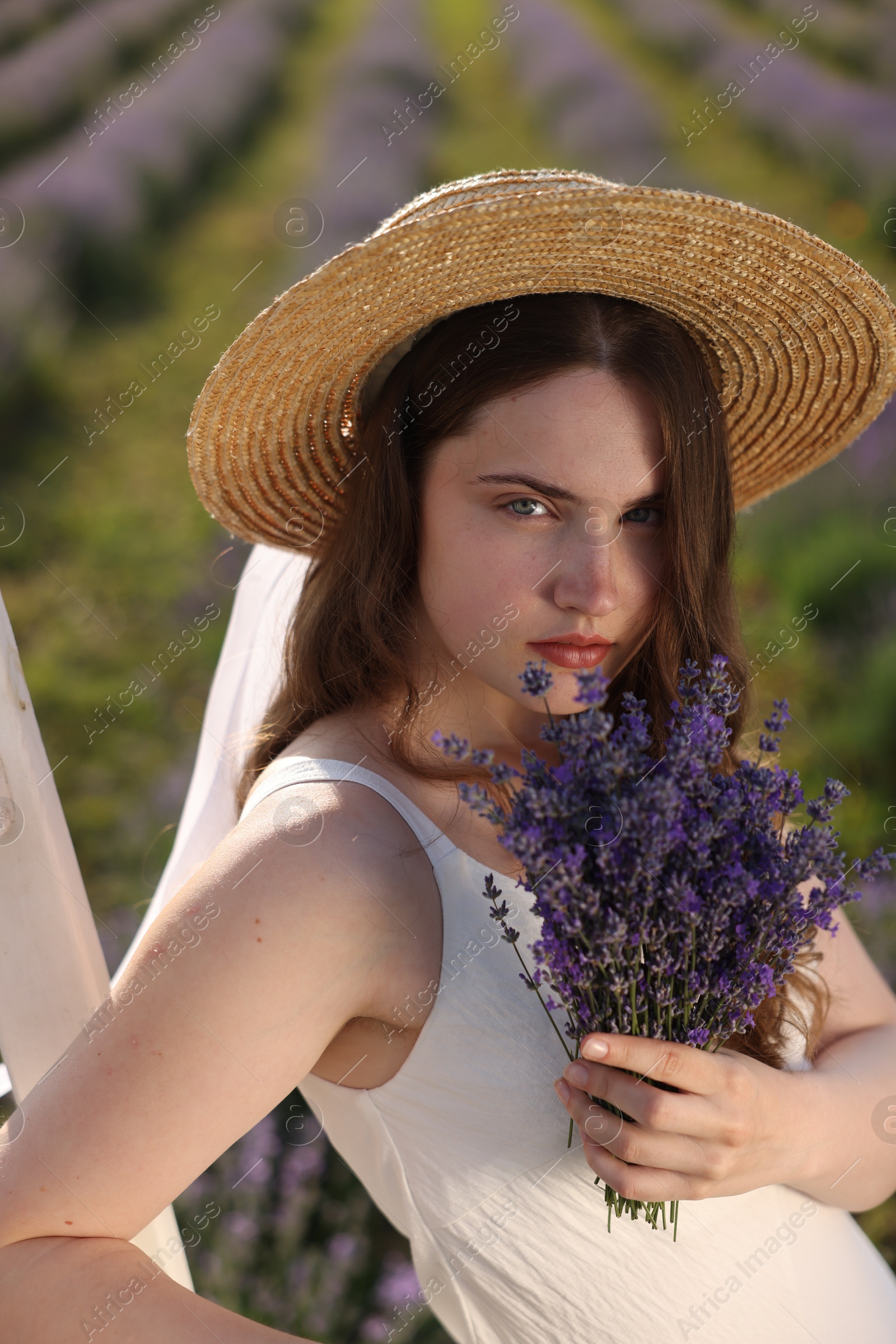 Photo of Beautiful young woman with lavender flowers outdoors