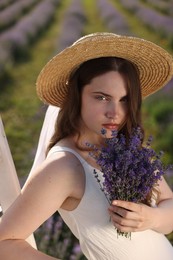Photo of Beautiful young woman with lavender flowers outdoors