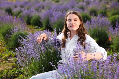 Photo of Beautiful young woman among lavender flowers in field