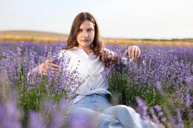 Photo of Beautiful young woman among lavender flowers in field
