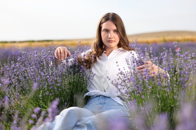 Photo of Beautiful young woman among lavender flowers in field