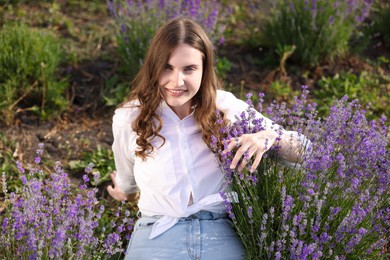 Photo of Beautiful young woman among lavender flowers in field