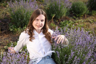 Photo of Beautiful young woman among lavender flowers in field