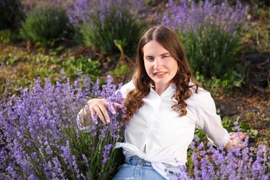 Photo of Beautiful young woman among lavender flowers in field