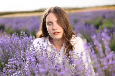 Photo of Beautiful young woman among lavender flowers in field