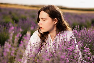 Photo of Beautiful young woman among lavender flowers in field