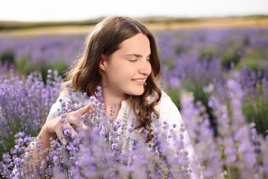 Photo of Beautiful young woman among lavender flowers in field