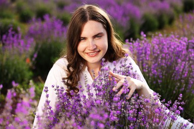 Photo of Beautiful young woman among lavender flowers in field