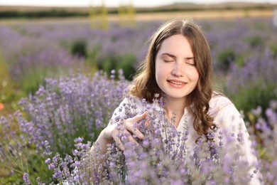 Photo of Beautiful young woman among flowers in lavender field. Space for text