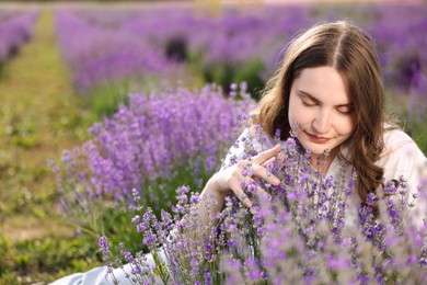 Photo of Beautiful young woman among flowers in lavender field. Space for text