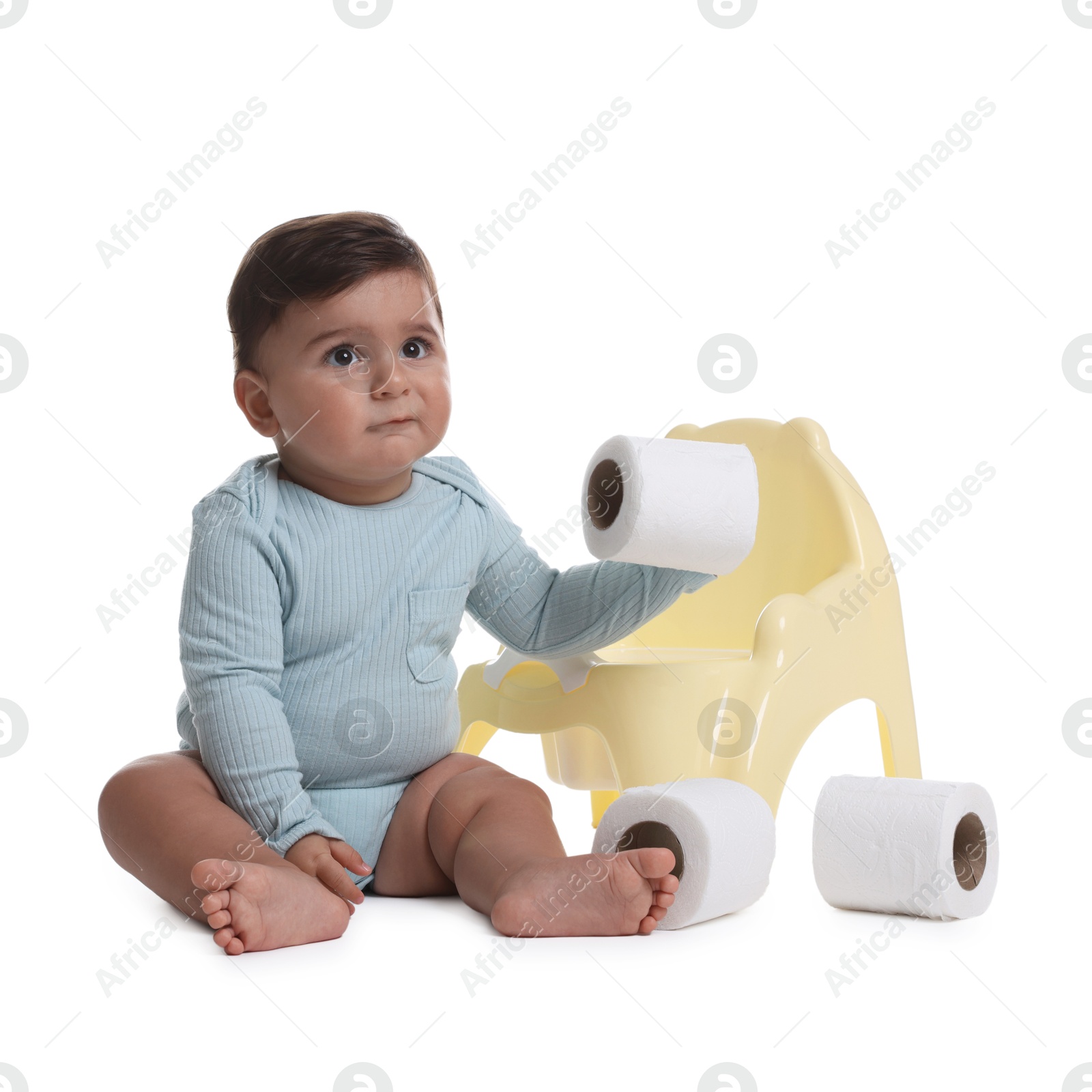 Photo of Cute little baby with rolls of toilet paper near potty on white background