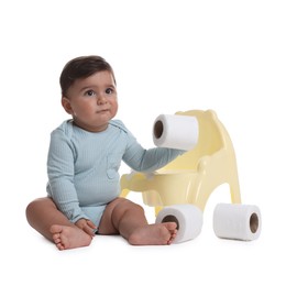 Photo of Cute little baby with rolls of toilet paper near potty on white background