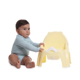 Photo of Cute little baby sitting near potty on white background