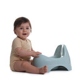 Photo of Cute little baby sitting near potty on white background