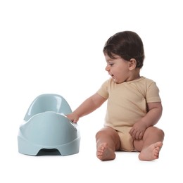 Photo of Cute little baby sitting near potty on white background