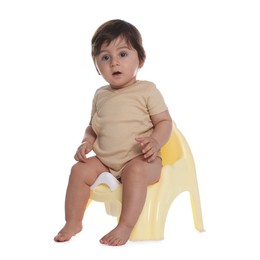 Photo of Cute little baby sitting on potty against white background