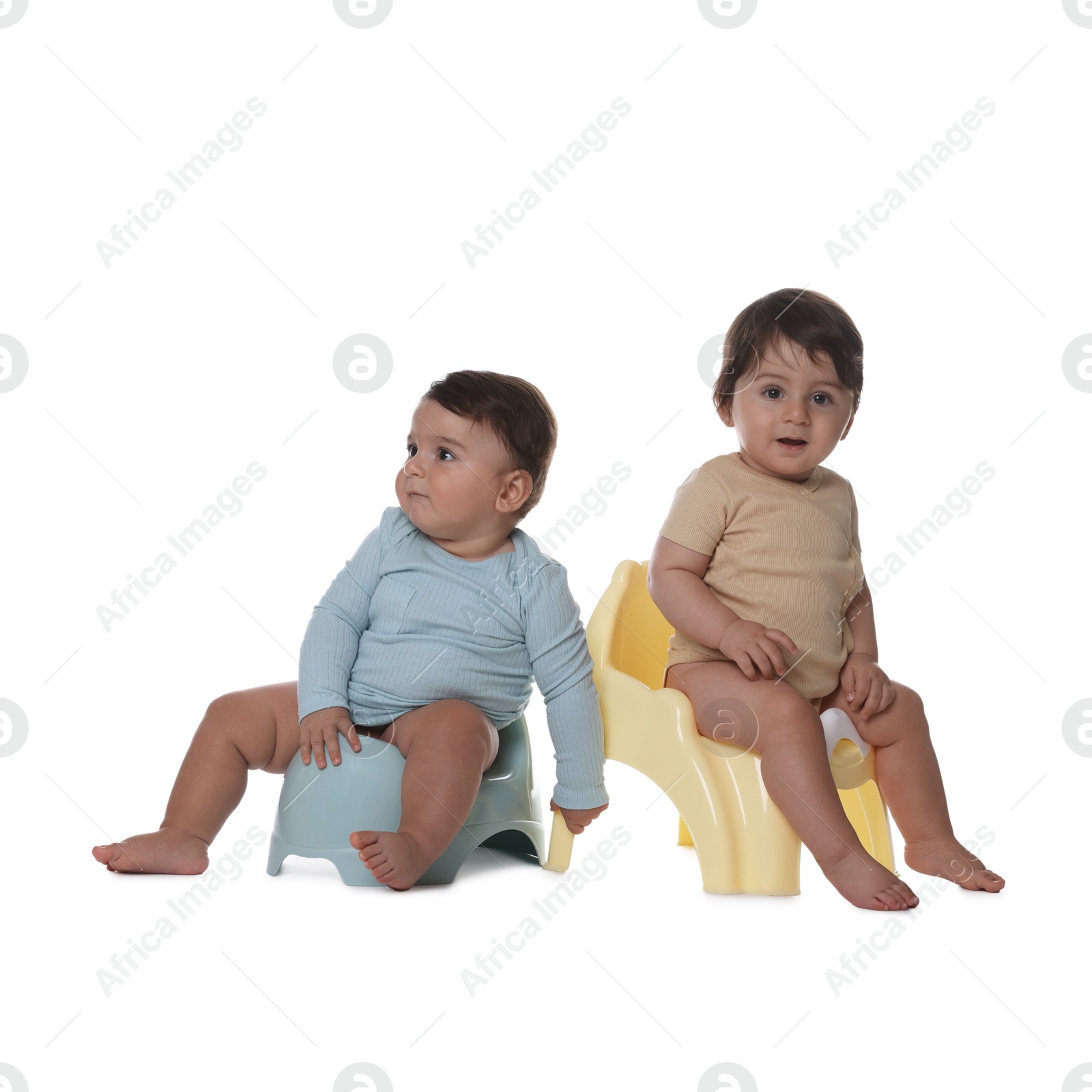 Photo of Cute little babies sitting on potties against white background