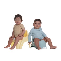 Photo of Cute little babies sitting on potties against white background