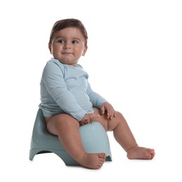 Photo of Cute little baby sitting on potty against white background