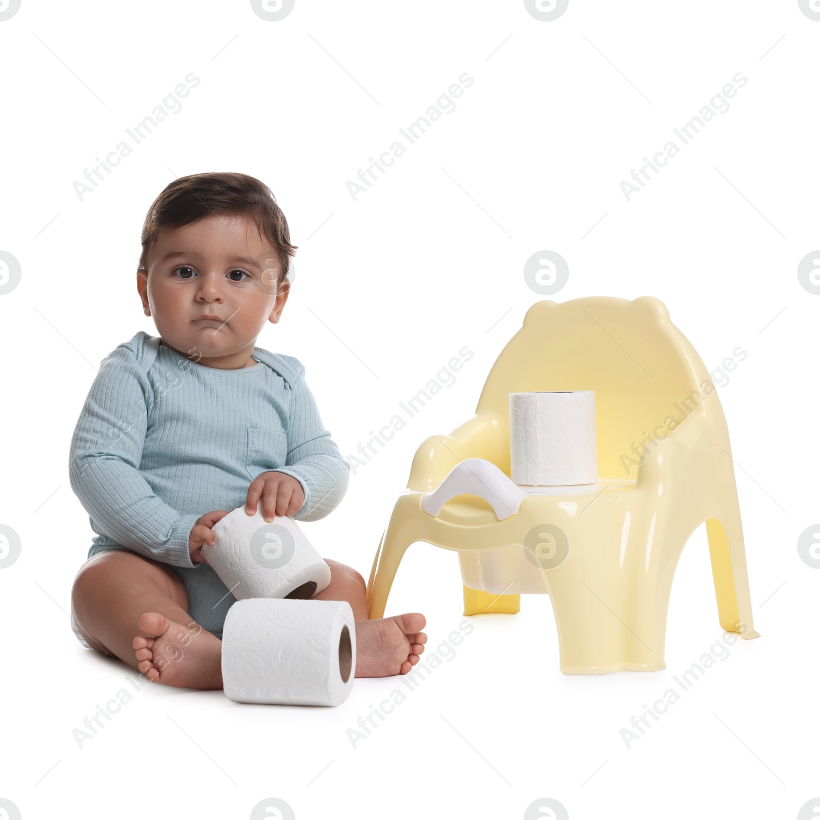Photo of Cute little baby with rolls of toilet paper near potty on white background