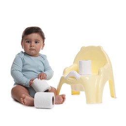 Photo of Cute little baby with rolls of toilet paper near potty on white background