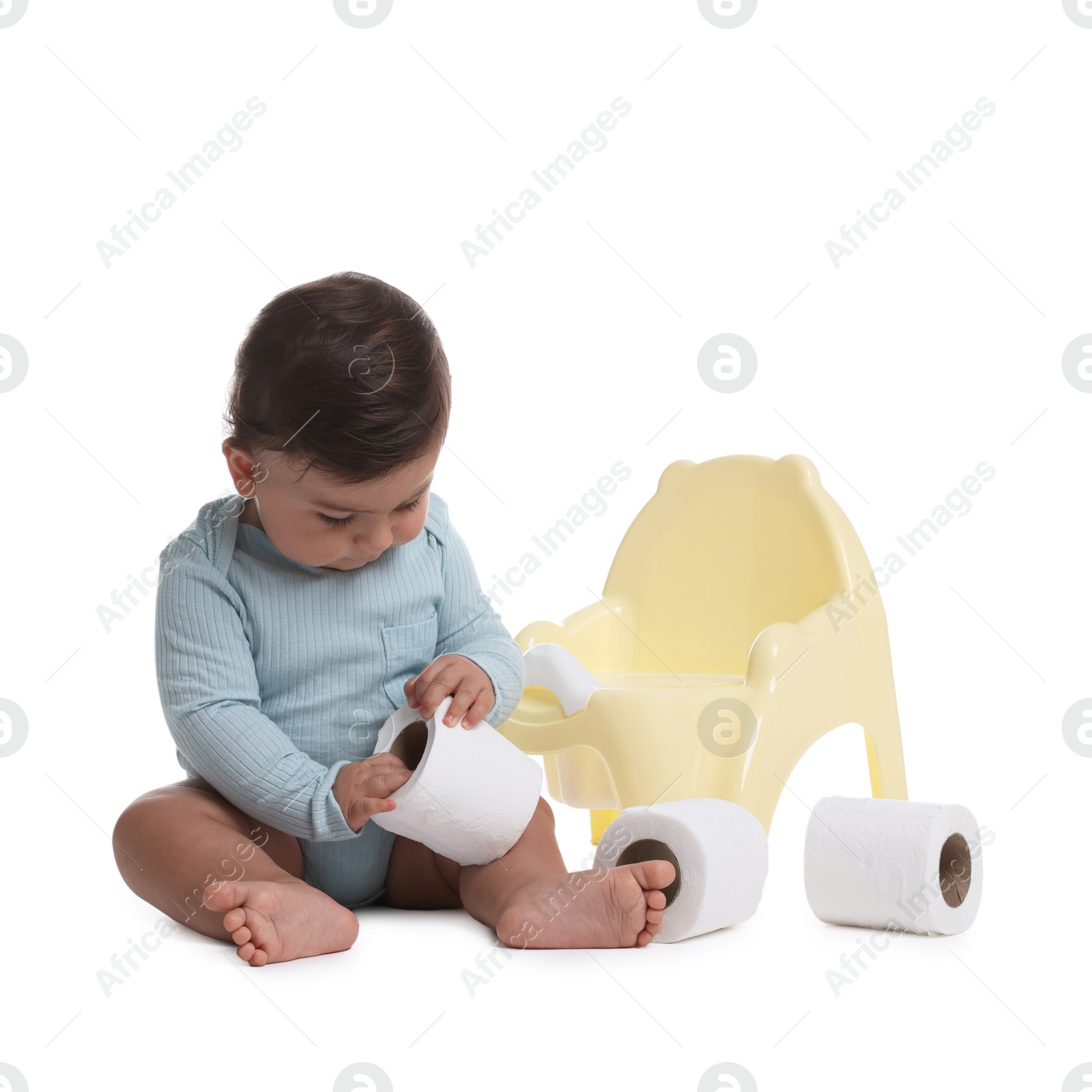 Photo of Cute little baby with rolls of toilet paper near potty on white background