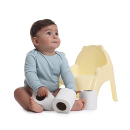 Photo of Cute little baby with rolls of toilet paper near potty on white background