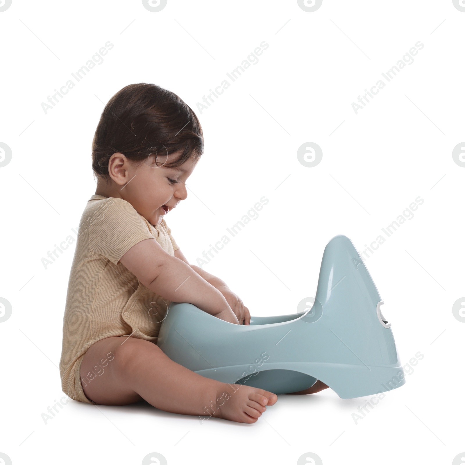 Photo of Cute little baby sitting near potty on white background