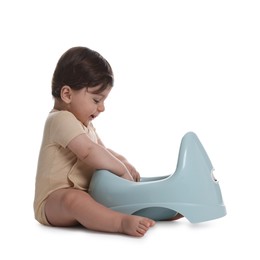 Photo of Cute little baby sitting near potty on white background