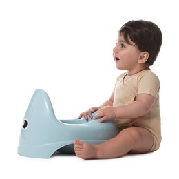 Photo of Cute little baby sitting near potty on white background