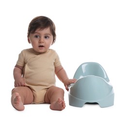 Photo of Cute little baby sitting near potty on white background